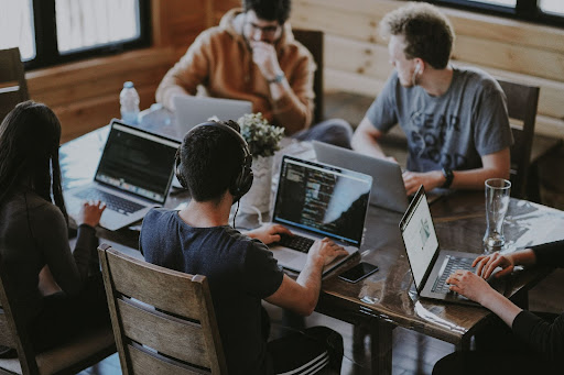 engineers around table working on laptop